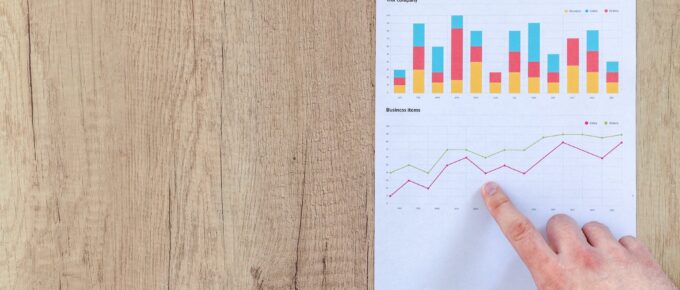 person pointing paper line graph